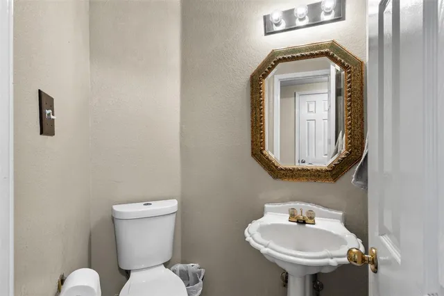 a bathroom with a toilet sink and mirror