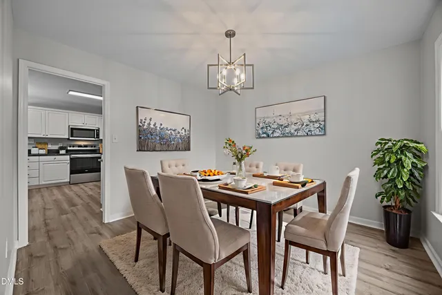 a view of a dining room with furniture wooden floor and chandelier