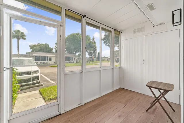 a view of a door and wooden floor in a room