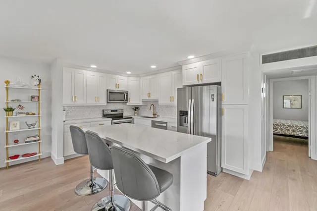 a kitchen with refrigerator a sink and chairs