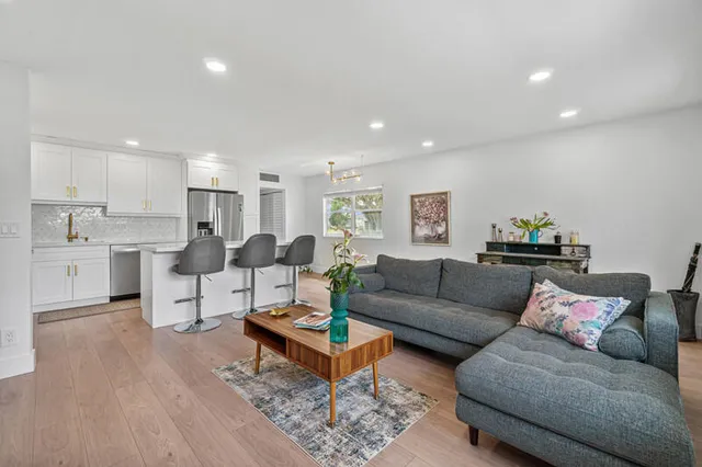 a living room with furniture and kitchen view