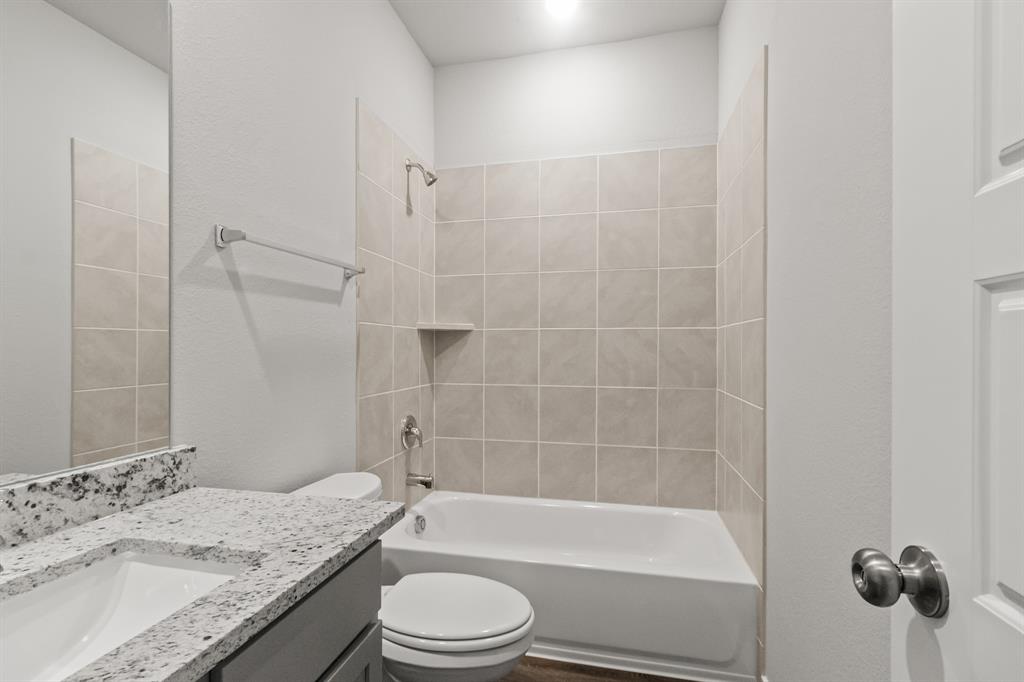 6909 Cattle Car Way Crowley, TX 76036 - Photo 13 of 24 a bathroom with a granite countertop bathtub shower sink vanity and toilet