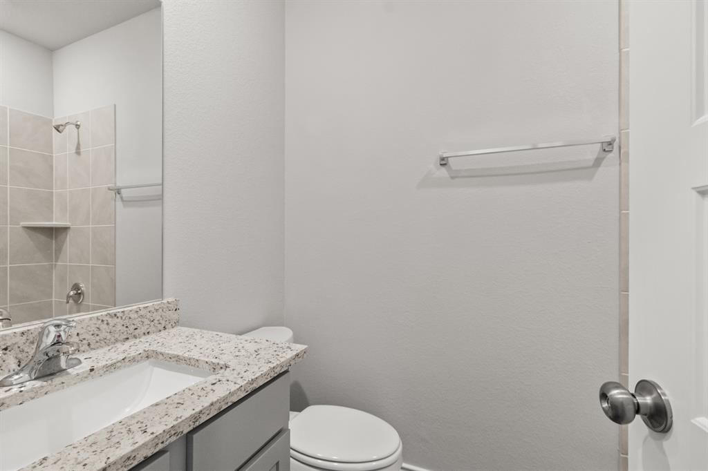 6909 Cattle Car Way Crowley, TX 76036 - Photo 10 of 24 a bathroom with a granite countertop toilet sink and mirror