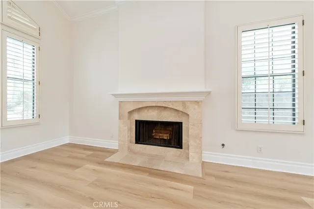 a view of an empty room with fireplace and a window