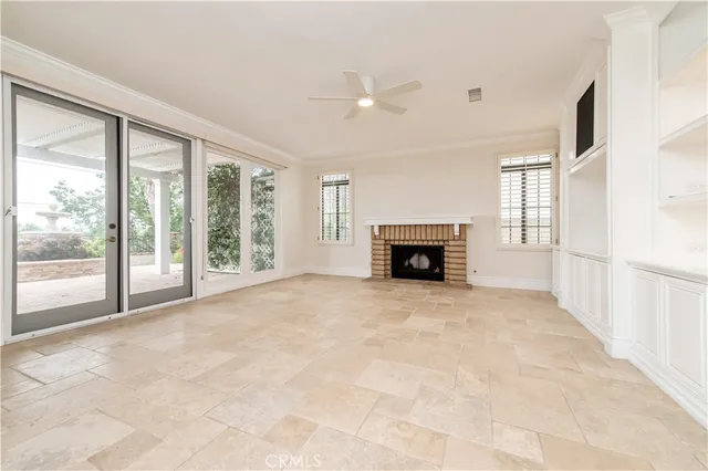 a view of an empty room with a fireplace and a window