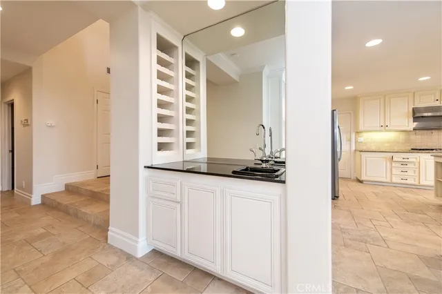 a kitchen with stainless steel appliances a refrigerator and white cabinets