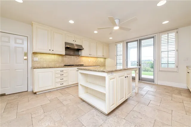 a kitchen with kitchen island granite countertop a stove and a sink