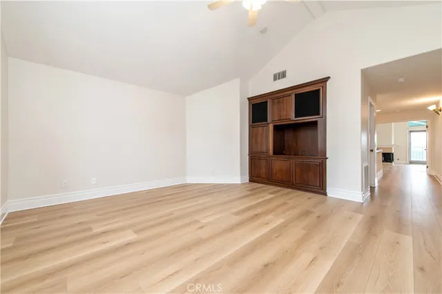 a view of an empty room with a fireplace and a window