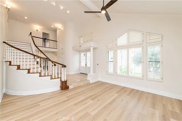 a view of a livingroom with a chandelier wooden floor and windows