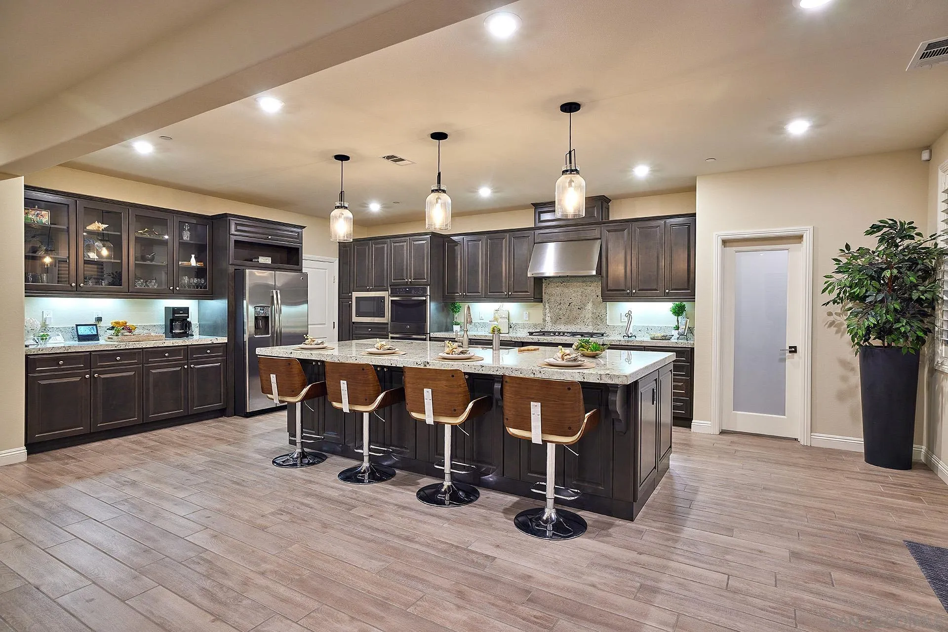 1179 Tesoro Place Vista, CA 92081 - Photo 4 of 49 a kitchen with stainless steel appliances kitchen island granite countertop a table chairs and a refrigerator