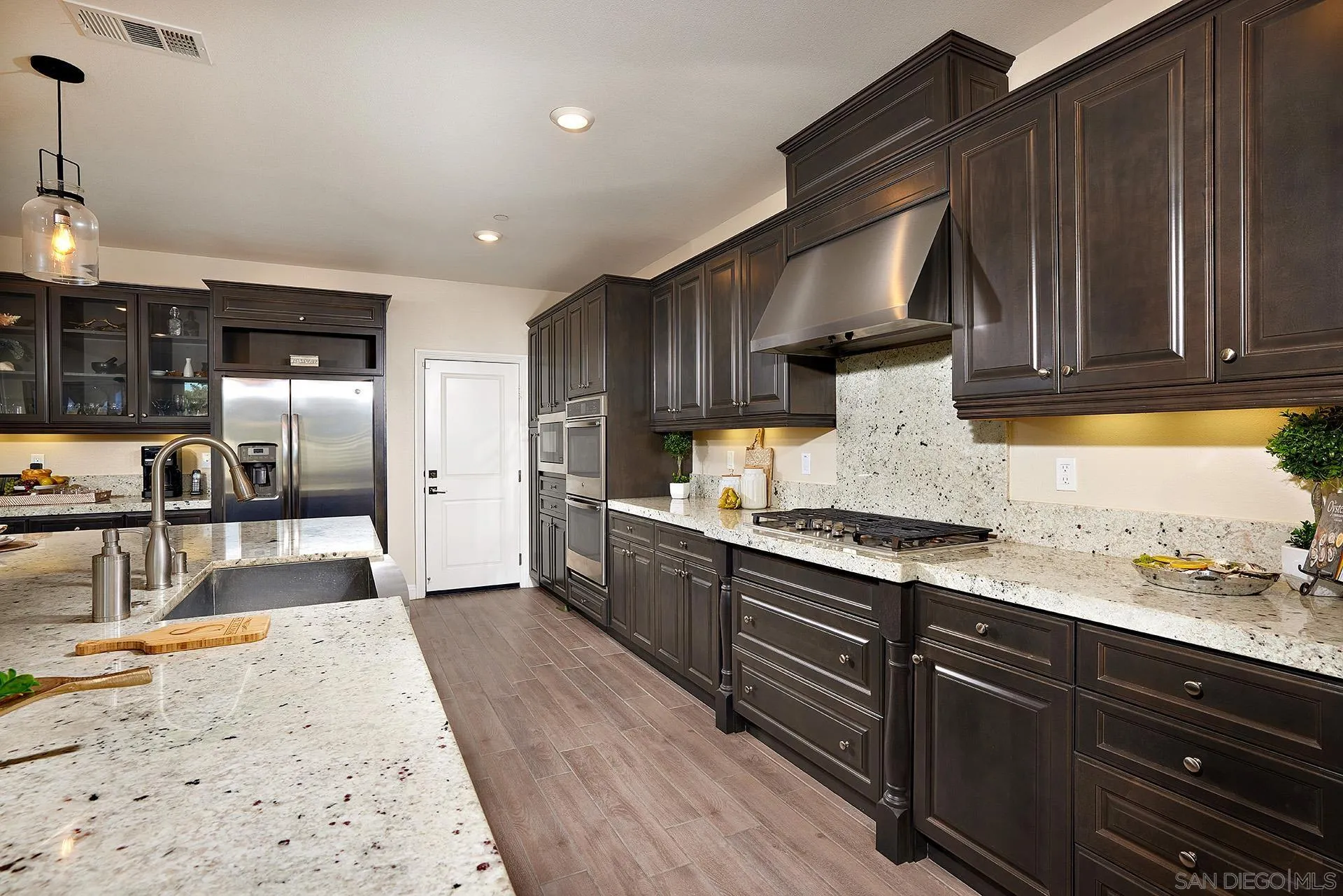 1179 Tesoro Place Vista, CA 92081 - Photo 8 of 49 a kitchen with stainless steel appliances granite countertop wooden cabinets a refrigerator and a stove