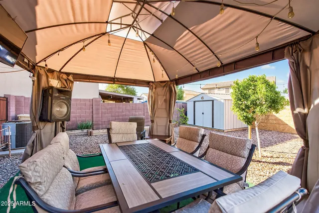 a patio with a table and chairs under an umbrella