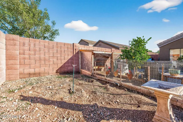 a backyard of a house with barbeque oven table and chairs