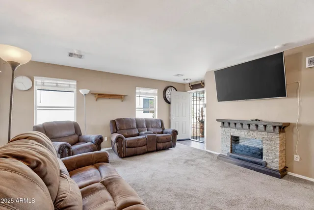 a living room with furniture a flat screen tv and a fireplace