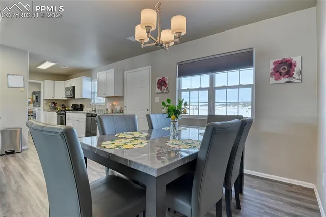 a view of a dining room with furniture a chandelier and wooden floor