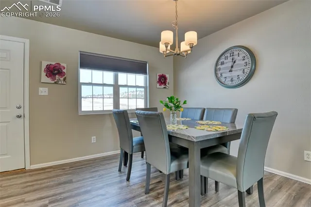 a view of a dining room with furniture a chandelier and wooden floor