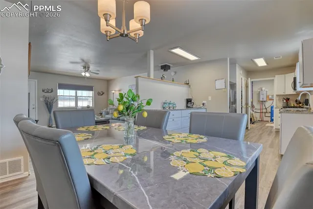 a kitchen with stainless steel appliances granite countertop a stove top oven a sink dishwasher and white cabinets with wooden floor