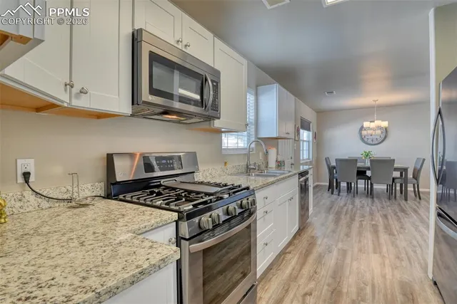 a kitchen with white cabinets and refrigerator