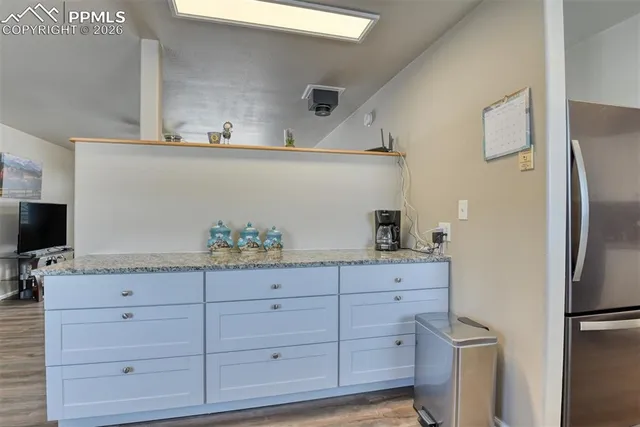 a kitchen with granite countertop white cabinets and white appliances