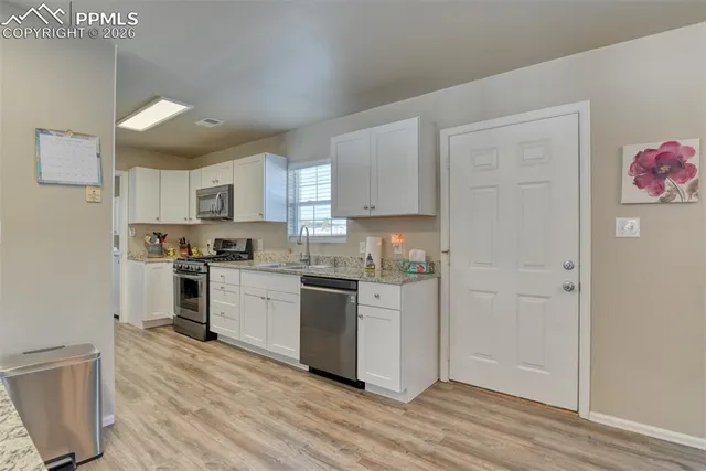 a view of a kitchen with furniture and wooden floor