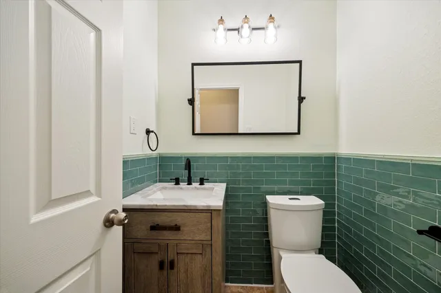 a bathroom with a toilet sink and mirror