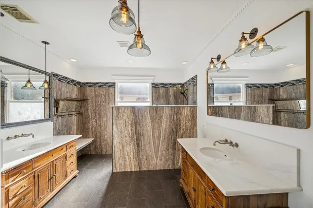 a bathroom with a double vanity sink a mirror and a bathtub