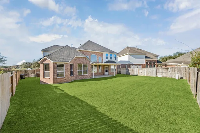 a view of a house with a big yard and large trees