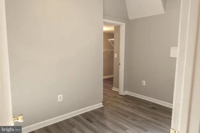 an empty room with wooden floor and closet