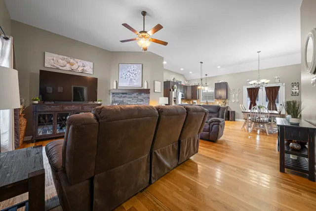 a living room with furniture flat screen tv and kitchen view