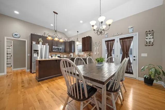 a view of a dining room with furniture a chandelier and wooden floor