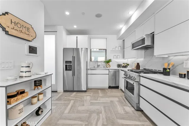 a kitchen with a sink a refrigerator and cabinets