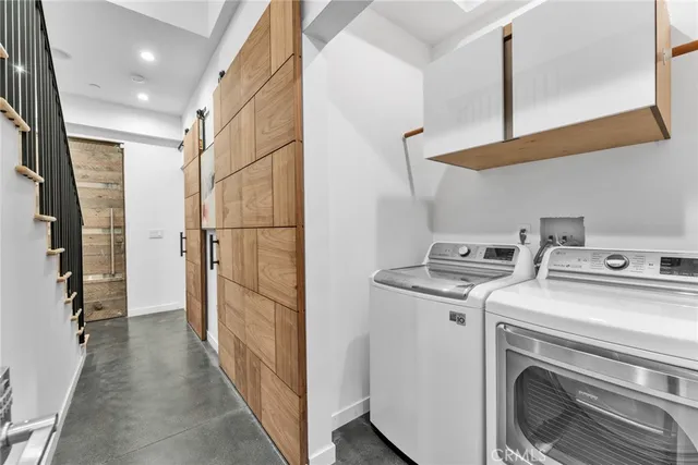 a view of washer and dryer with wooden walls