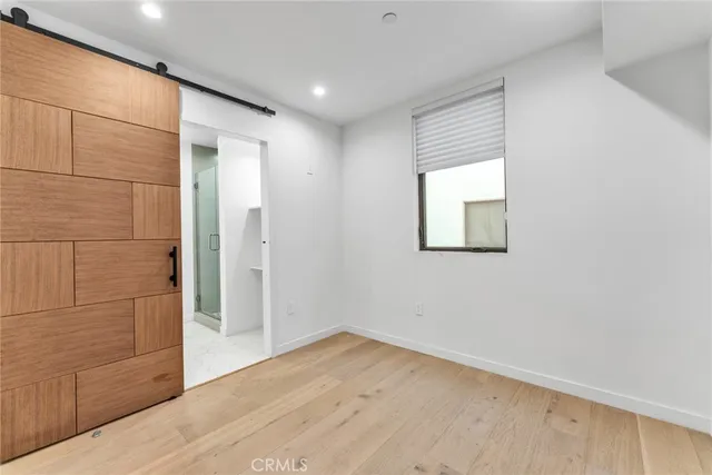 a view of empty room with wooden floor and cabinet