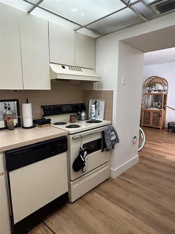 a kitchen with granite countertop a stove and a wooden floors