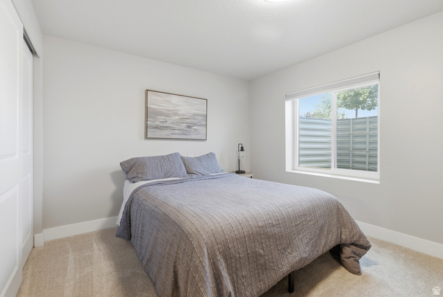 28 East Ginger Gold Road Santaquin, UT 84655 - Photo 27 of 36 Bright secondary bedroom with large windows featuring exterior shutters, neutral carpeting, and soft natural light