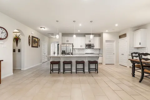 a large kitchen with kitchen island a dining table chairs and a chandelier