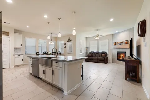 a kitchen with stainless steel appliances granite countertop a stove and a view of living room