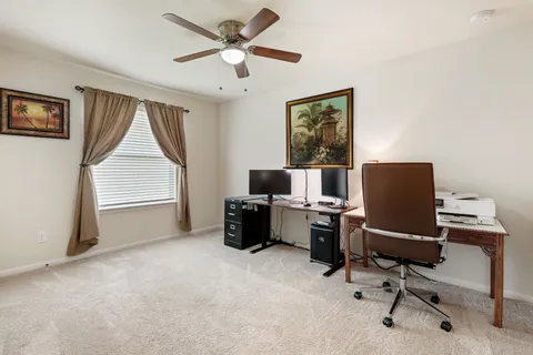 a view of a workspace with furniture and a window