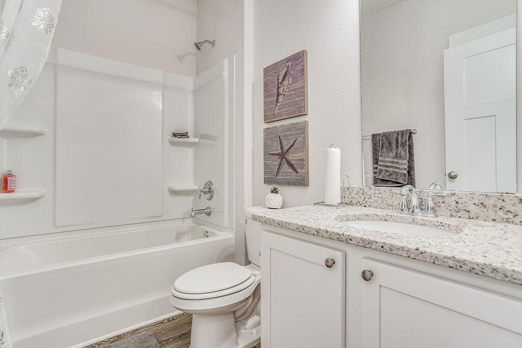 8587 Bluebell Street Milton, FL 32583 - Photo 24 of 30 a bathroom with a granite countertop sink toilet and shower