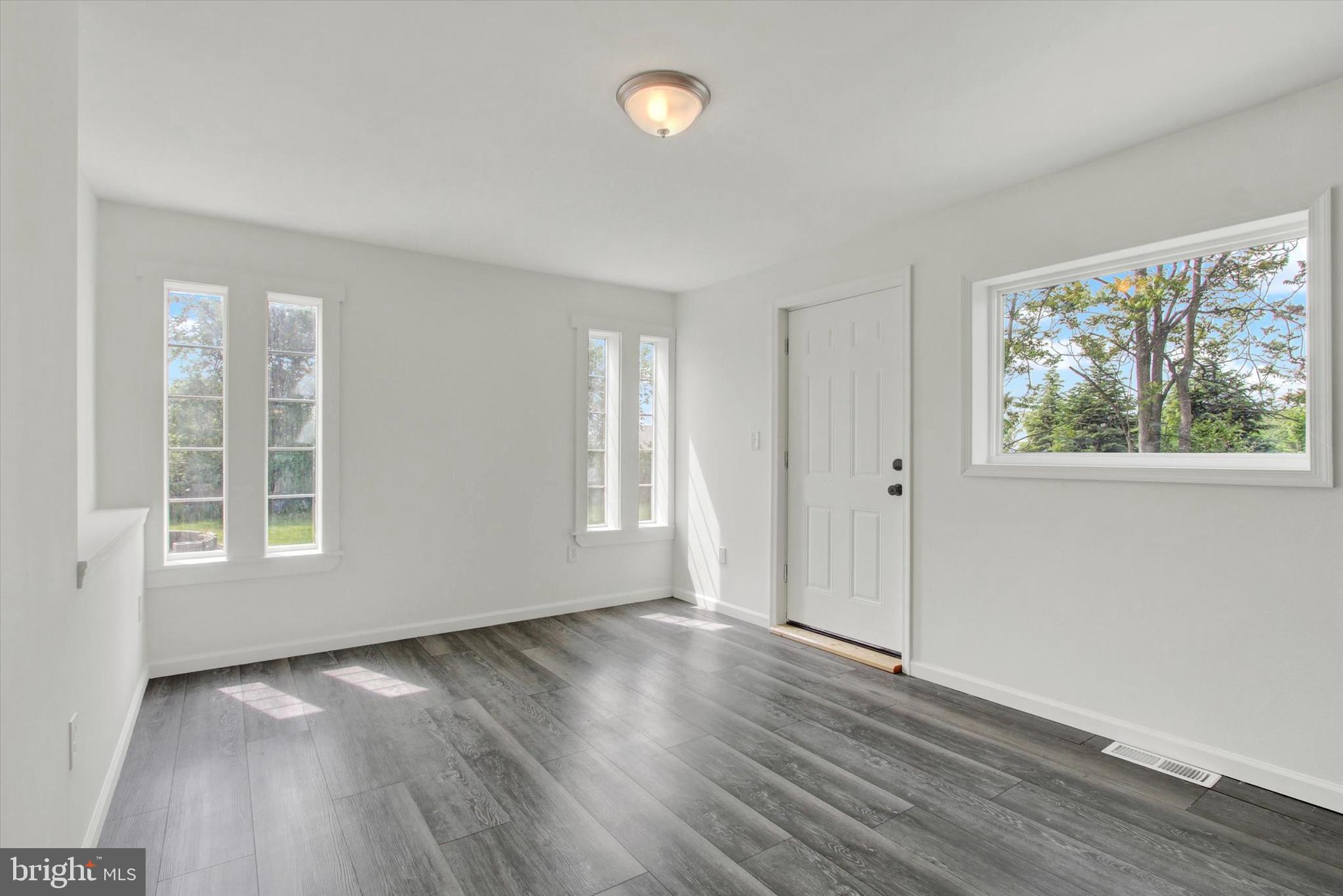 651 Alexander Spring Road Carlisle, PA 17015 - Photo 11 of 28 an empty room with wooden floor and windows
