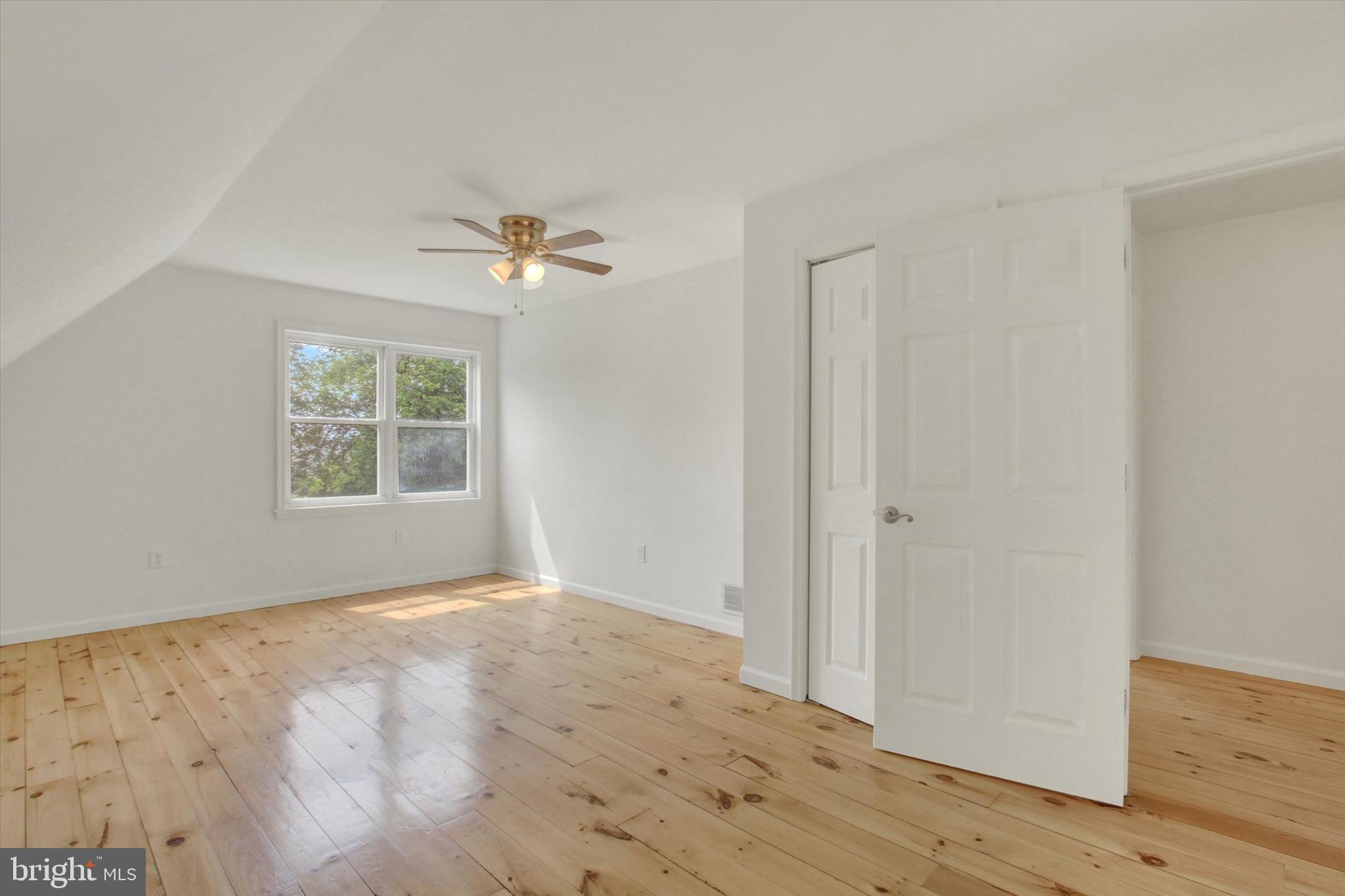 651 Alexander Spring Road Carlisle, PA 17015 - Photo 20 of 28 an empty room with wooden floor chandelier fan and windows