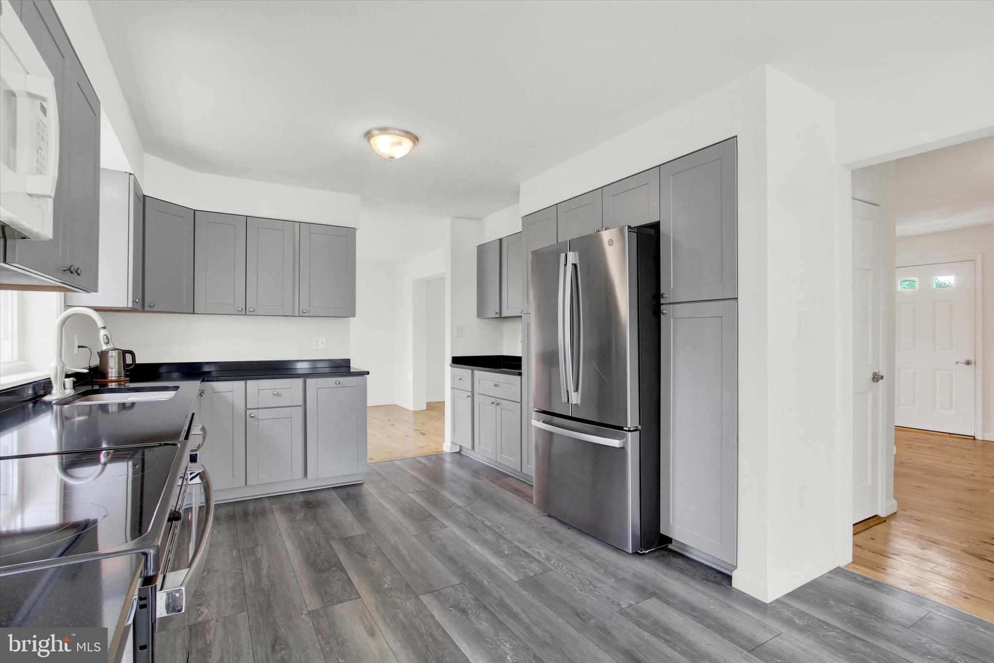 651 Alexander Spring Road Carlisle, PA 17015 - Photo 9 of 28 a kitchen with a refrigerator stove and wooden floor