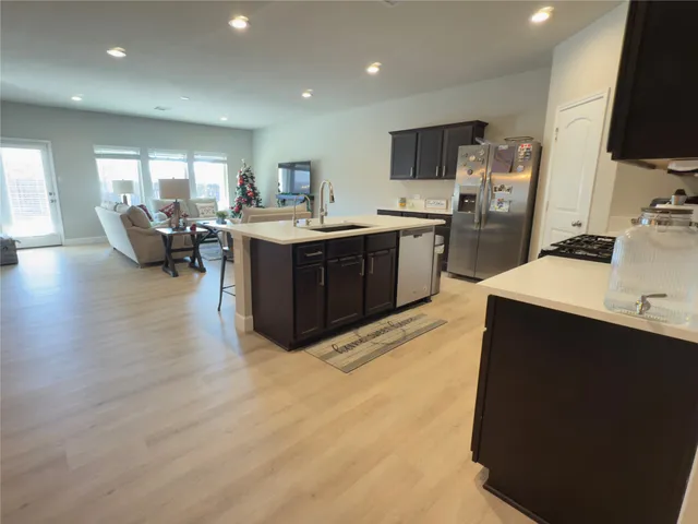 a kitchen with a sink a stove top oven and wooden cabinets