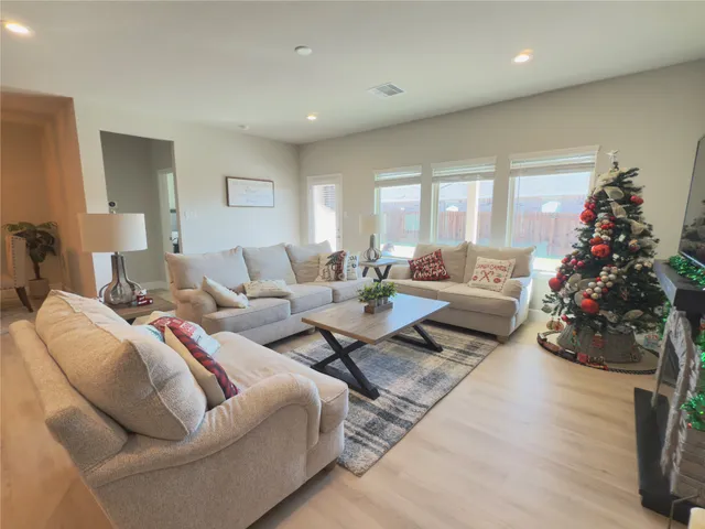 a living room with furniture and a view of kitchen