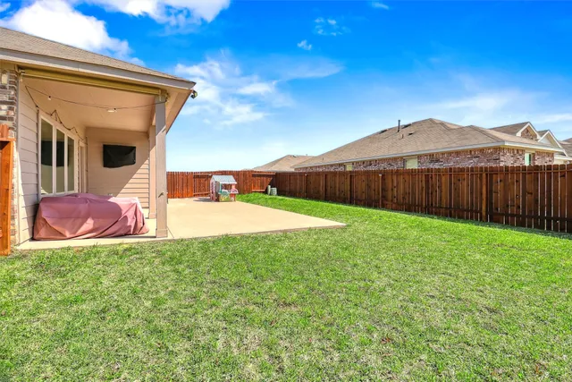 a view of a patio with table and chairs with wooden fence