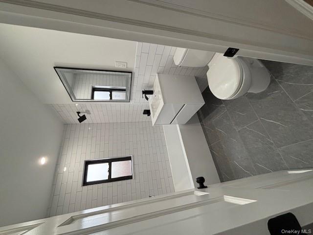 219-07 74th Avenue, Unit 447B2 Queens, NY 11364 - Photo 12 of 15 a bathroom with a toilet sink and mirror