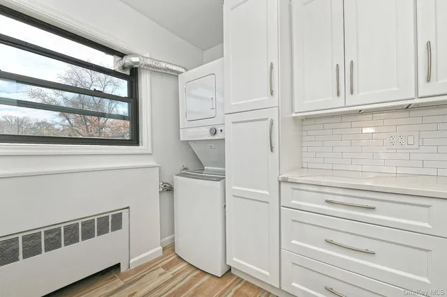 a kitchen with white cabinets and a window