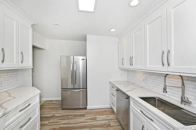 a kitchen with granite countertop a refrigerator and a sink