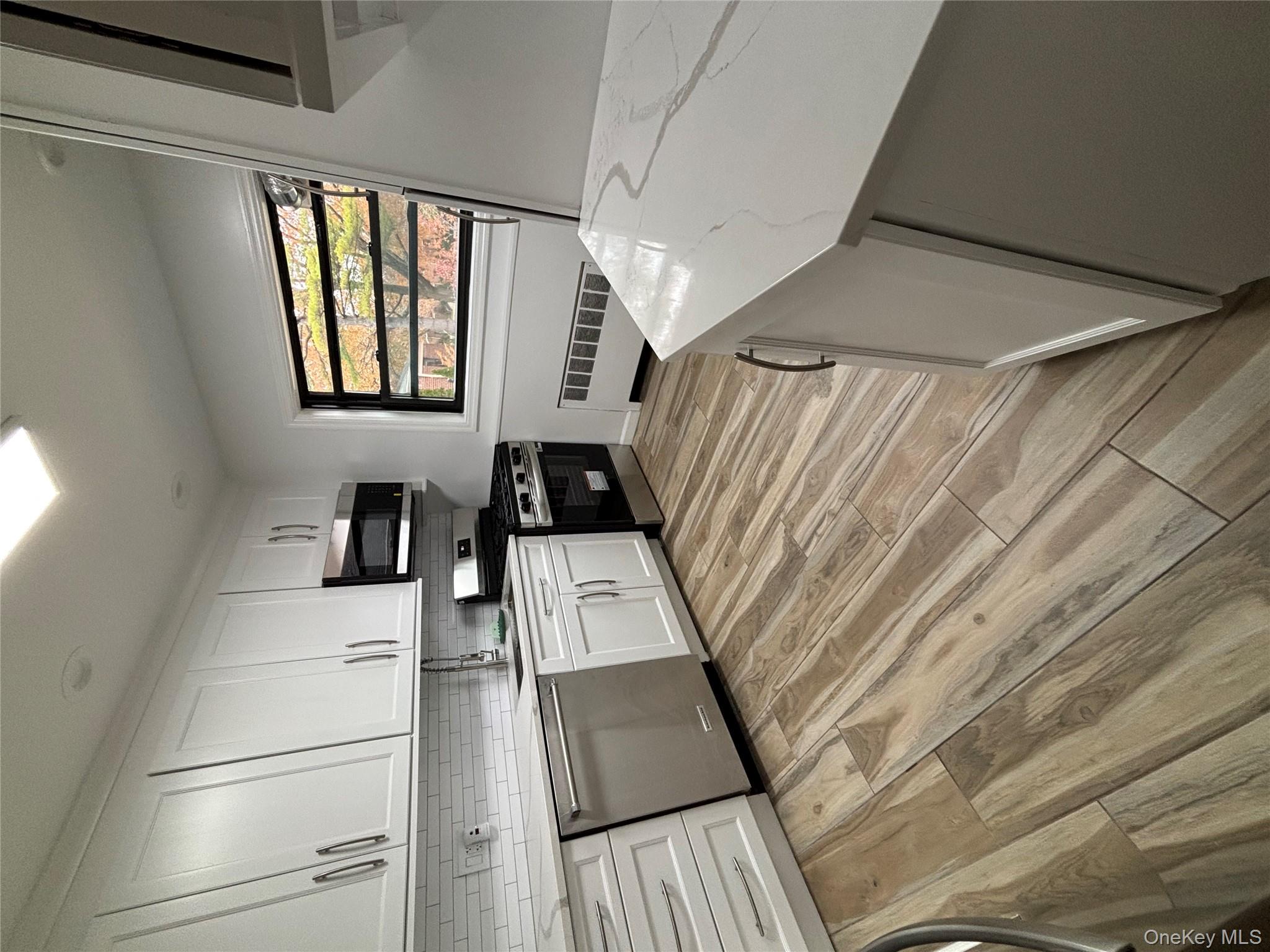 219-07 74th Avenue, Unit 447B2 Queens, NY 11364 - Photo 5 of 15 a kitchen with stainless steel appliances a stove sink and cabinets