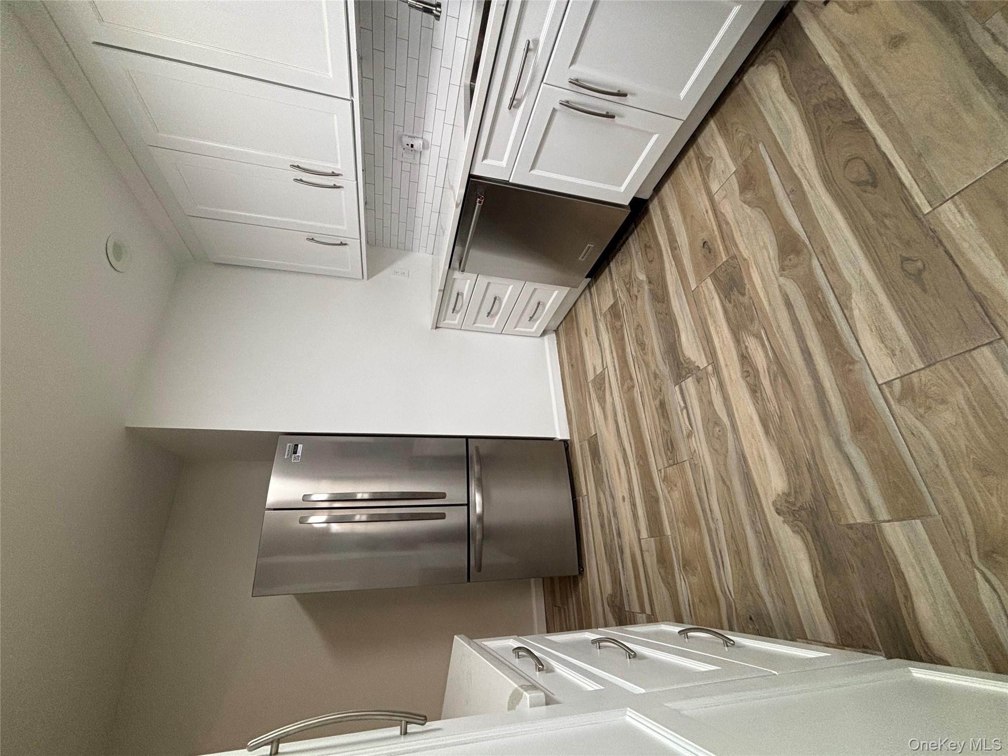 219-07 74th Avenue, Unit 447B2 Queens, NY 11364 - Photo 7 of 15 a view of kitchen and empty room with fireplace